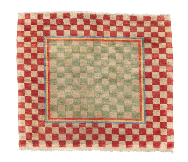 Late 19th-century Tibetan rug with traditional design, featuring reweaving and wear visible, available through Christie's auction